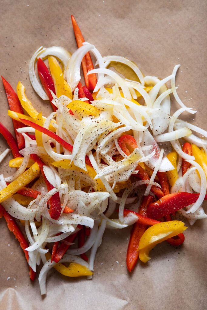 sliced bell peppers and onions on a sheet pan