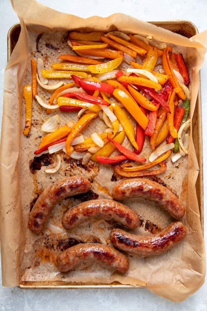 cooked italian sausages peppers and onions on a sheet pan