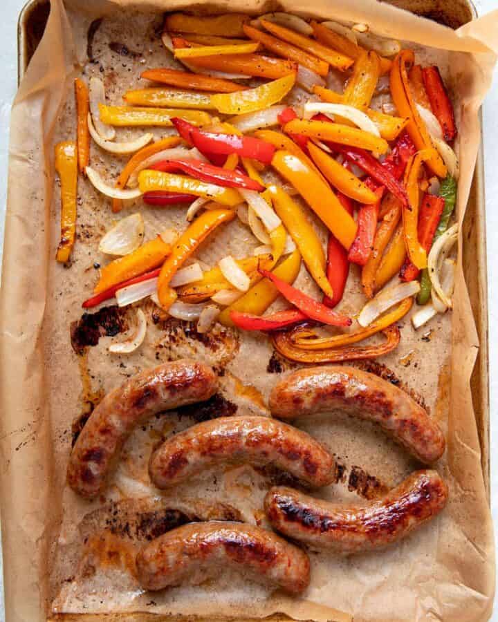 cooked italian sausages peppers and onions on a sheet pan