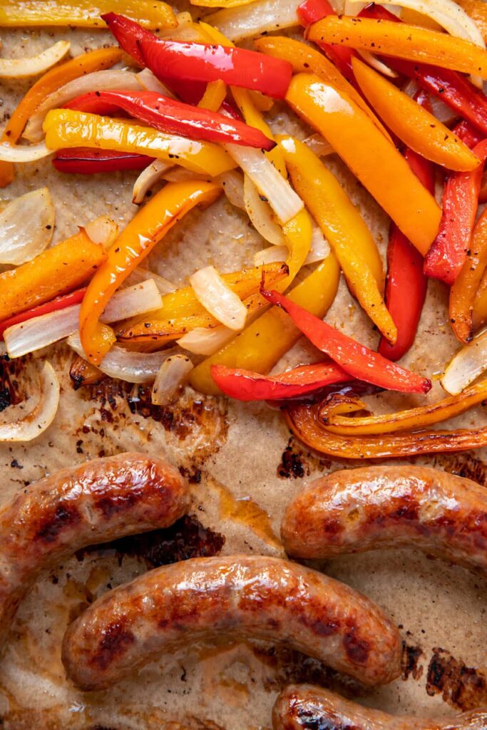 cooked italian sausages peppers and onions on a sheet pan