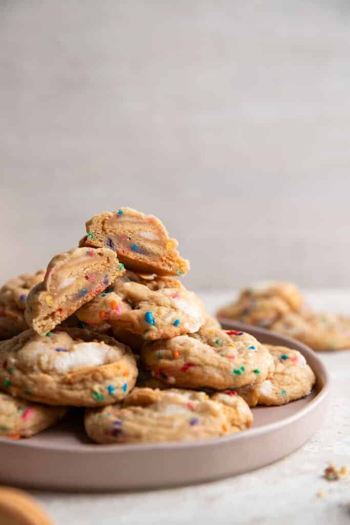 close of up a plate of sprinkle cookies with one cut in half