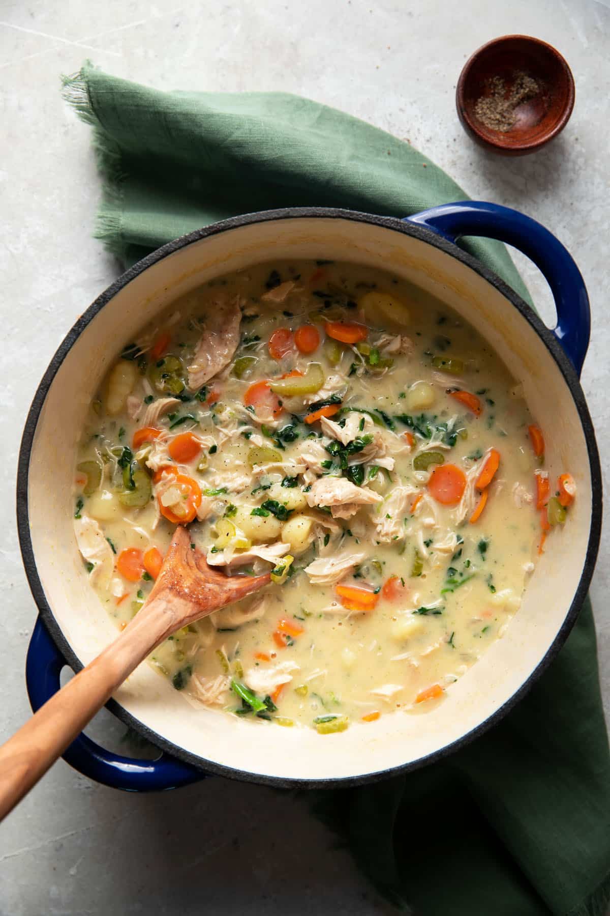 gnocchi soup with vegetables in a white bowl