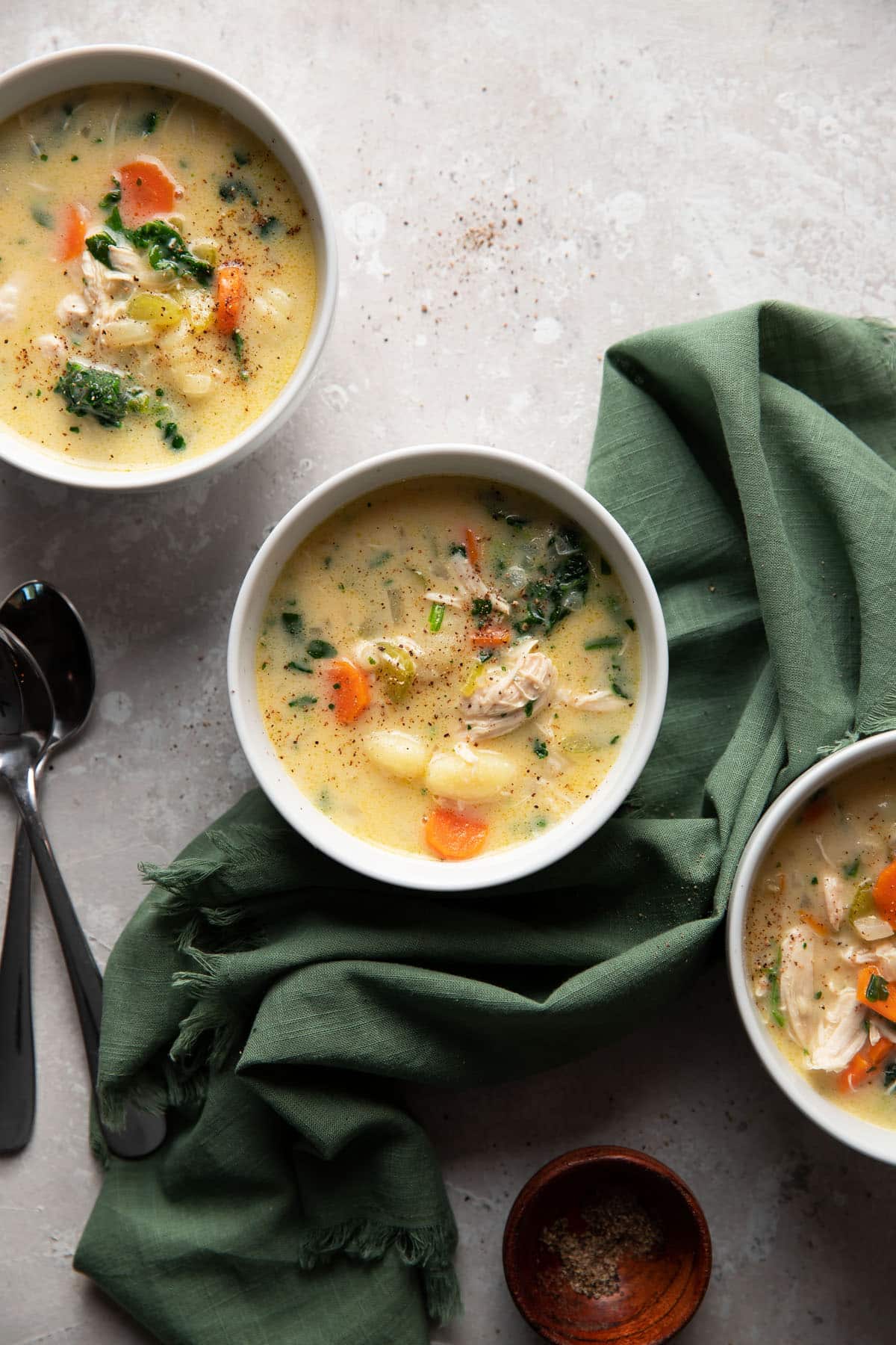 gnocchi soup with vegetables in a white bowl