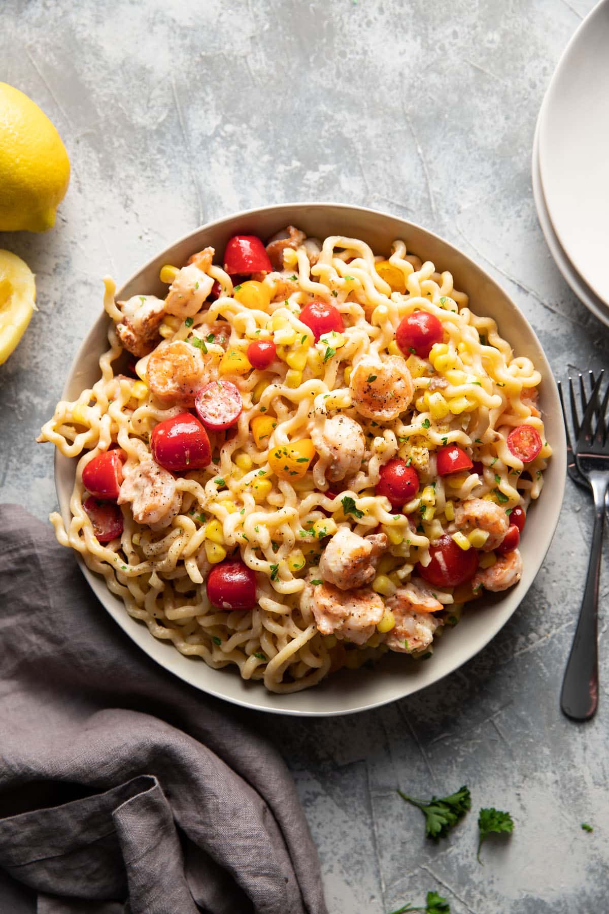 fusili pasta with shrimp corn and tomatoes in a bowl