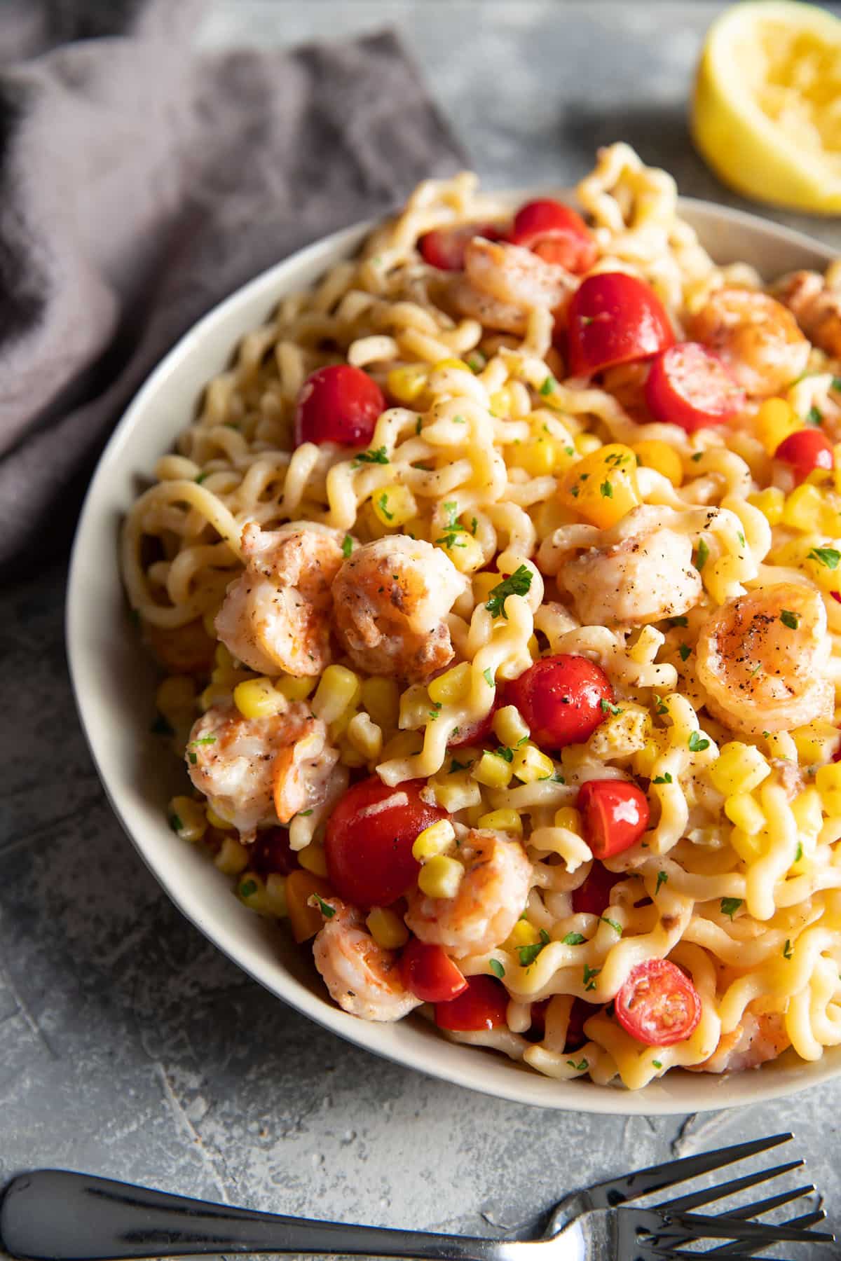 fusili pasta with shrimp corn and tomatoes in a bowl