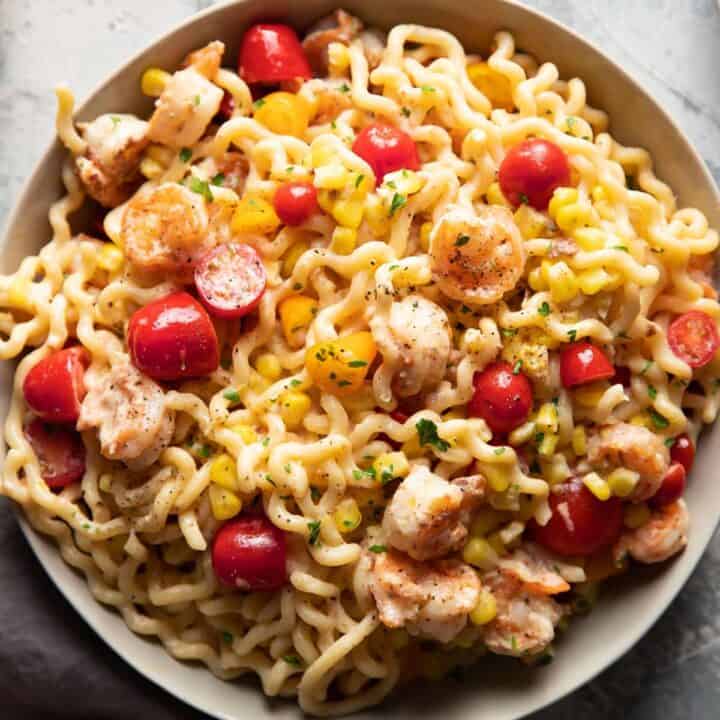 fusili pasta with shrimp corn and tomatoes in a bowl