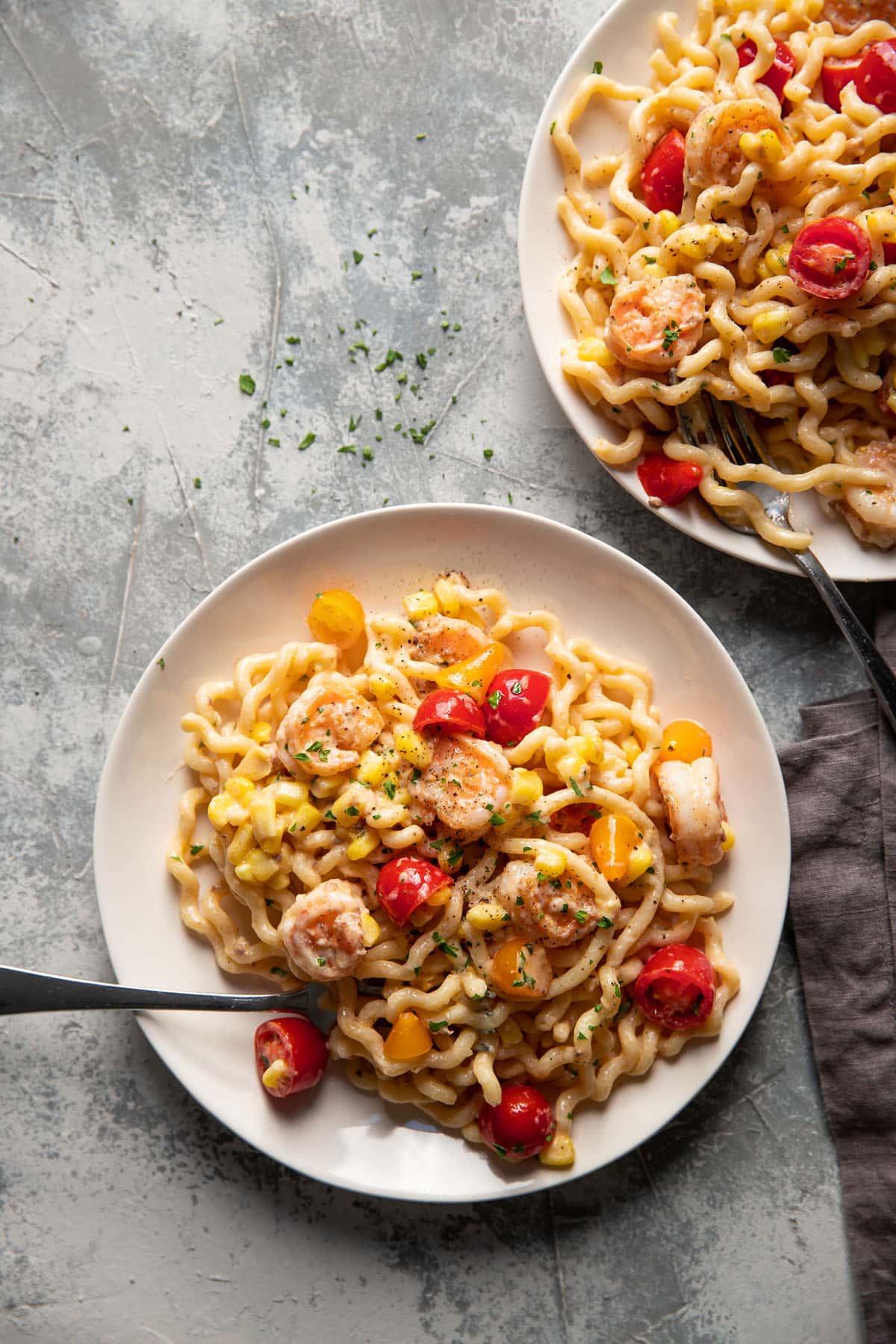 fusili pasta with shrimp corn and tomatoes on a plate
