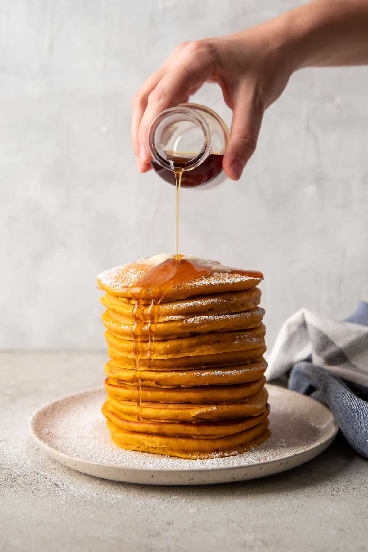 syrup pouring over pancakes