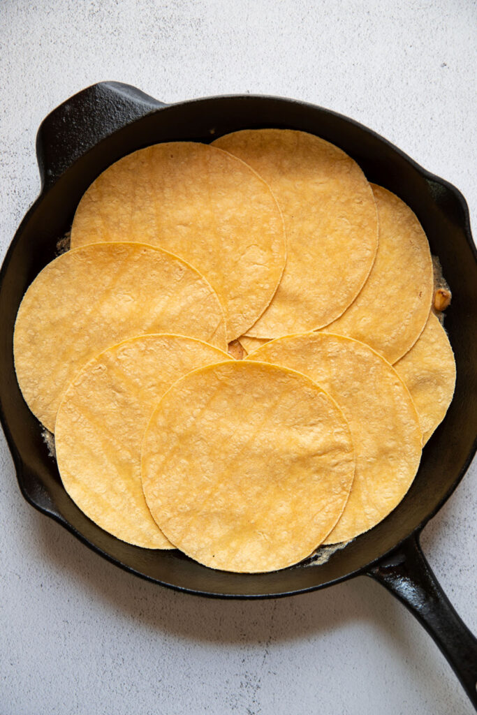 mexican street corn enchilada sauce and tortillas in a skillet