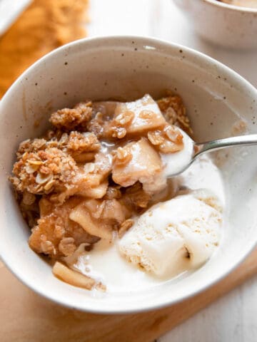 apple crisp in a bowl with a spoon.