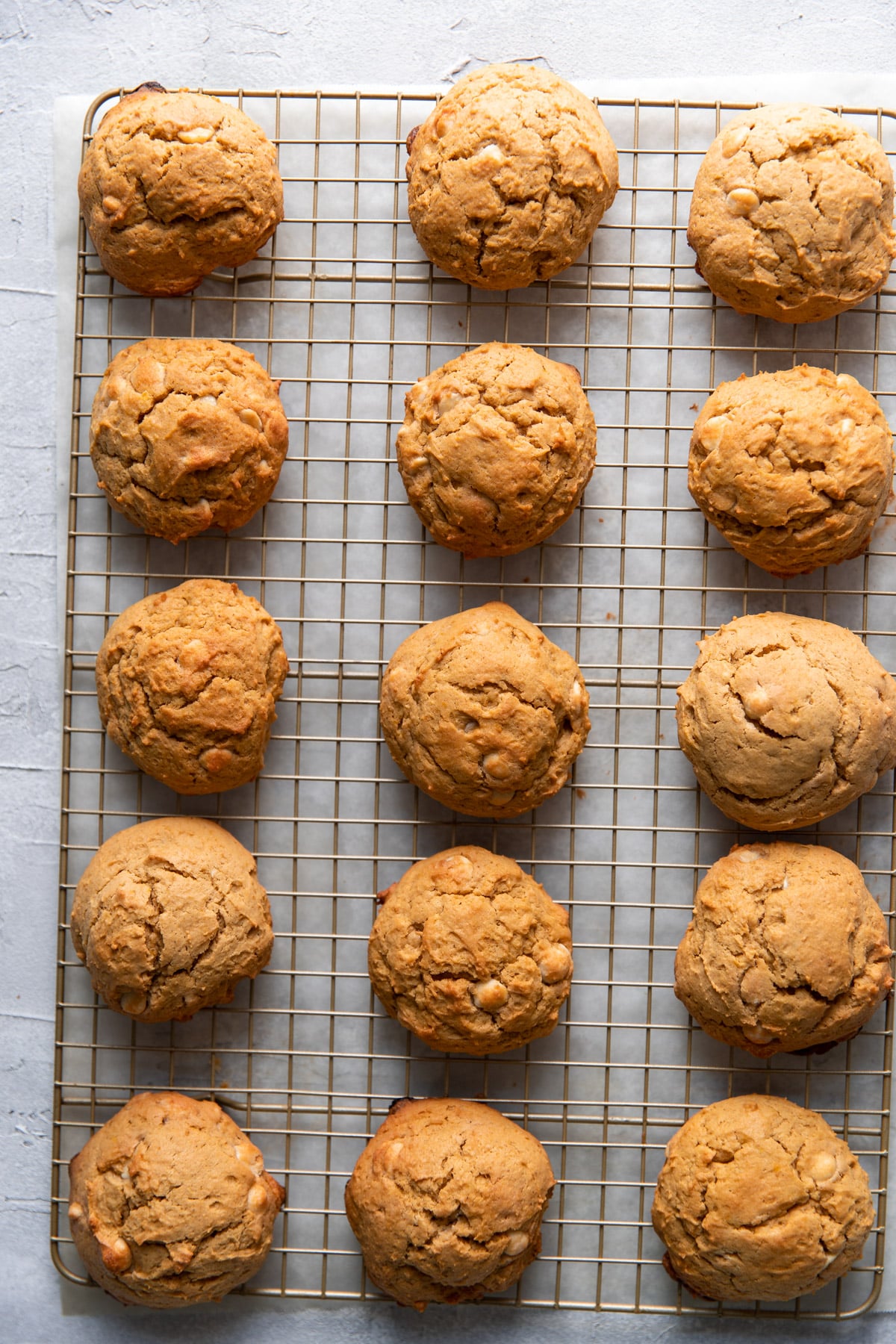 pumpkin cheesecake white chocolate chip cookies on a wire rack