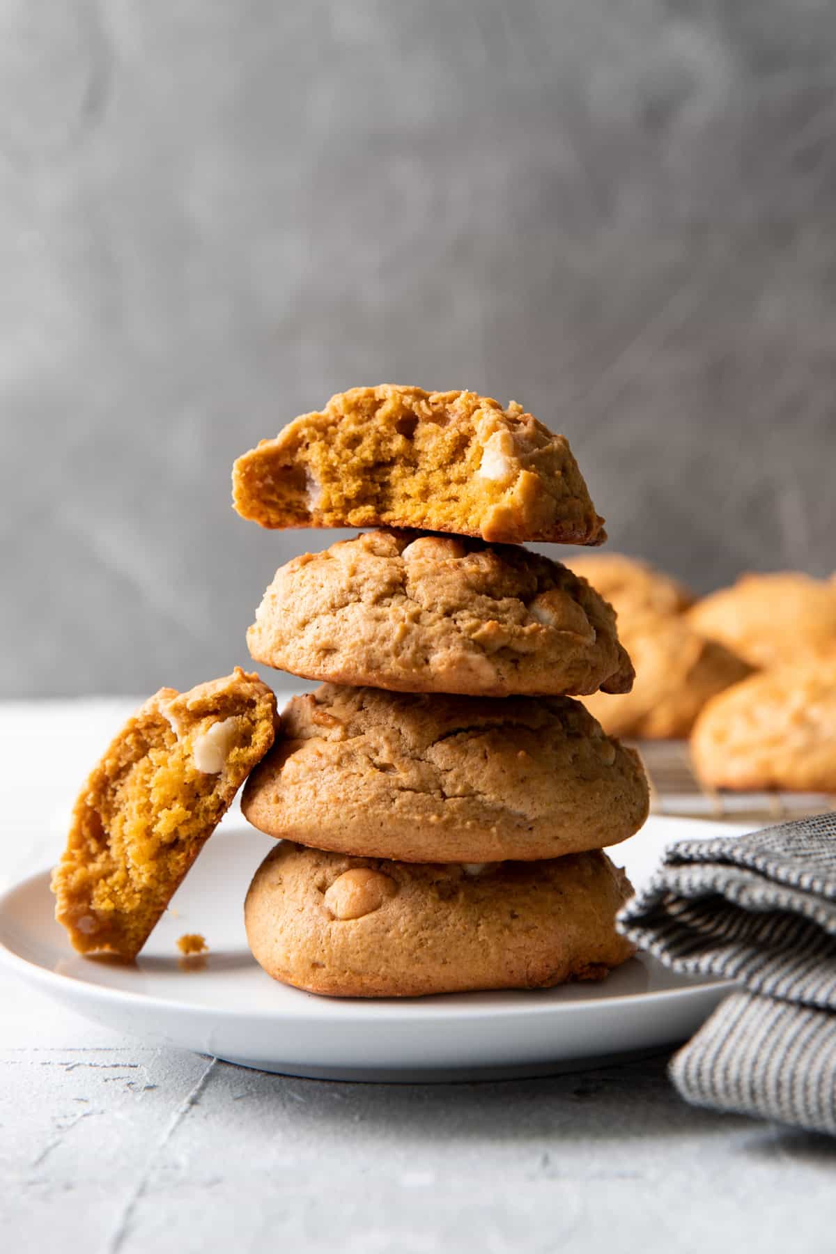 pumpkin cheesecake white chocolate chip cookies stacked on top of each other