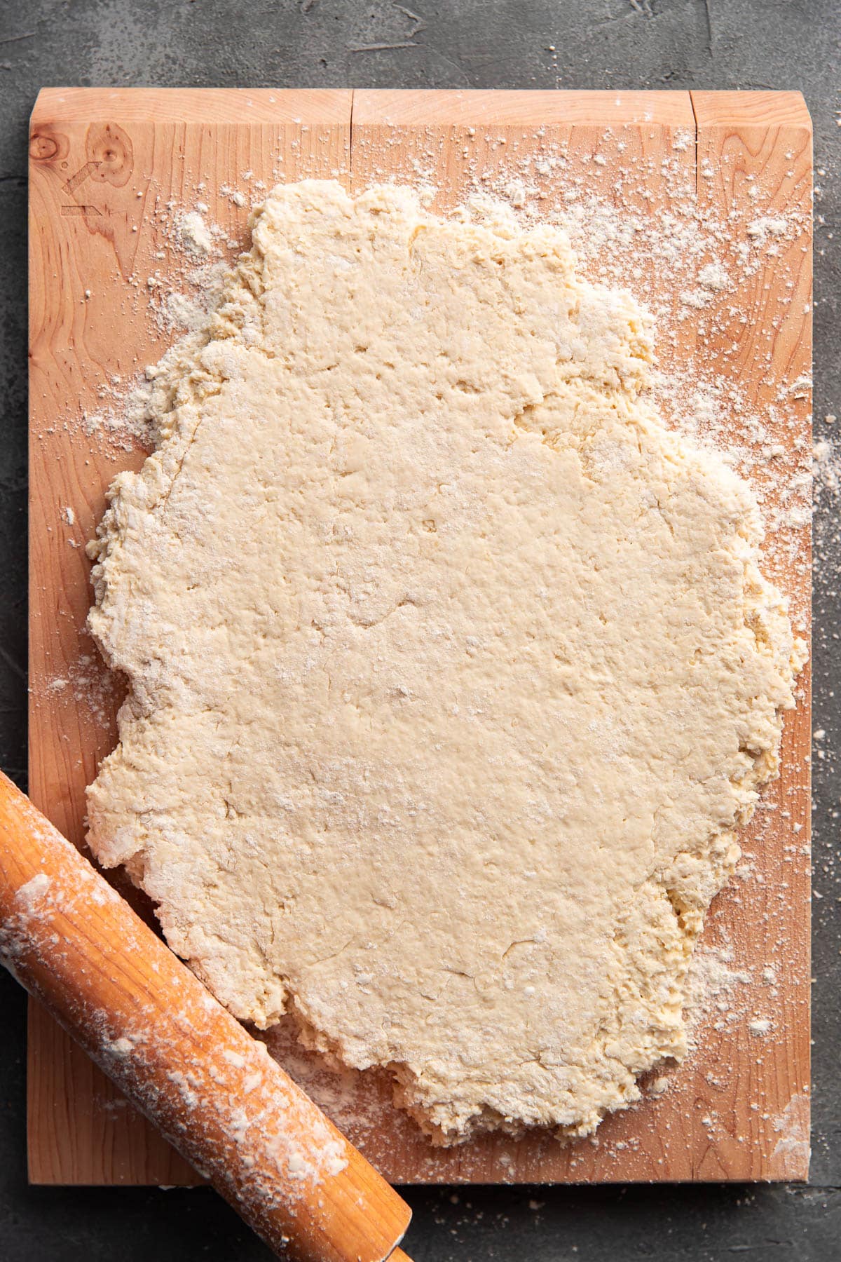 biscuit dough on a cutting board rolled out