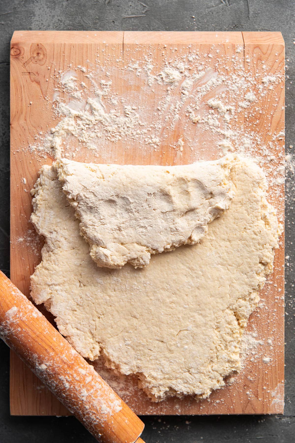 biscuit dough on a cutting board rolled out