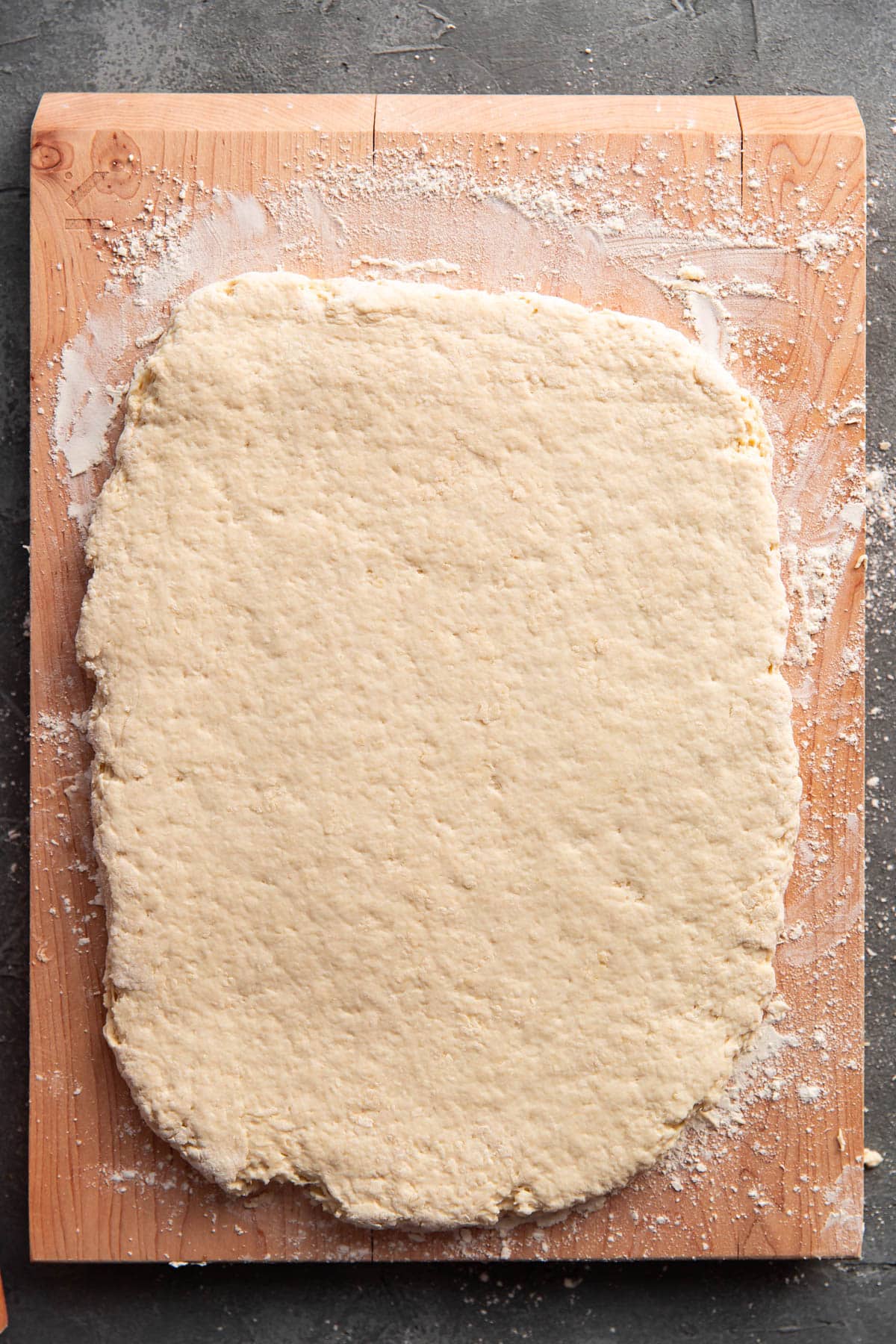 biscuit dough on a cutting board rolled out