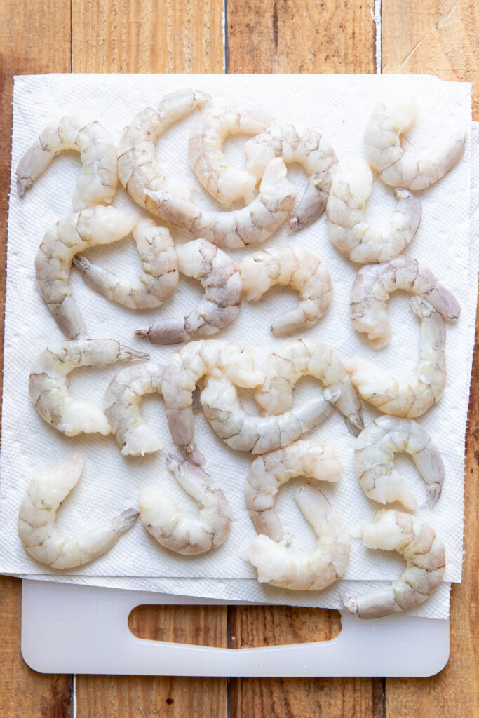 Shrimp on a cutting board with a paper towel.
