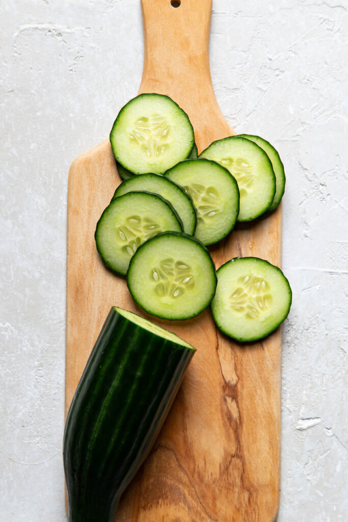 Sliced cucumbers on a cutting tray.