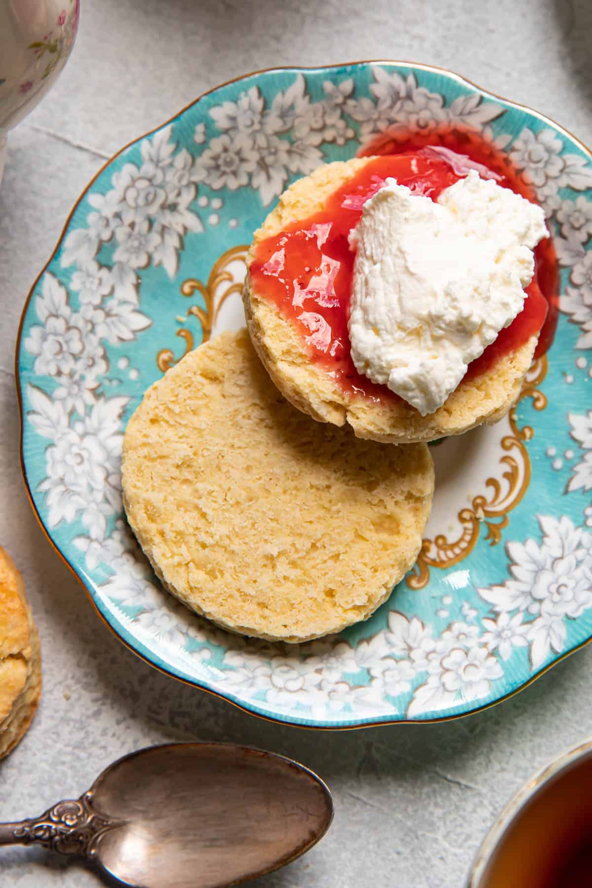 irish scone with jam and cream on a blue plate.