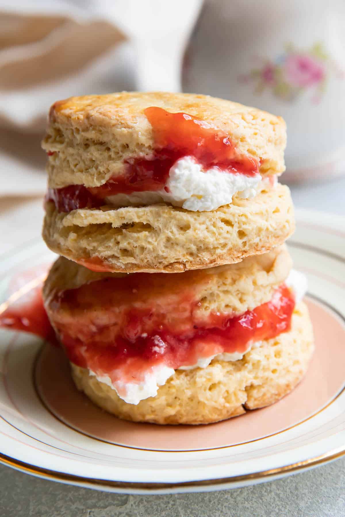 two irish scones stacked on top of each other, with cream and jam in the middle.