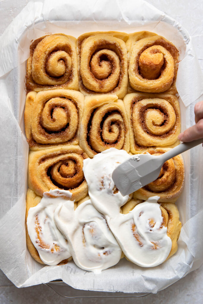 Orange rolls in a baking pan after cooking.