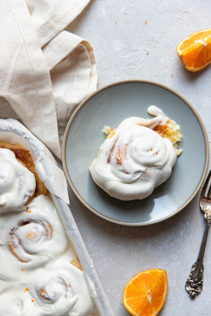 Orange rolls with cream cheese frosting on top.