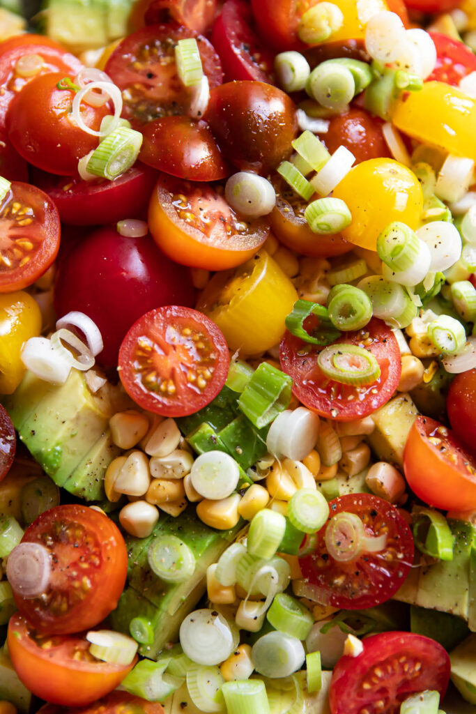 avocado corn and tomato salad in a bowl.