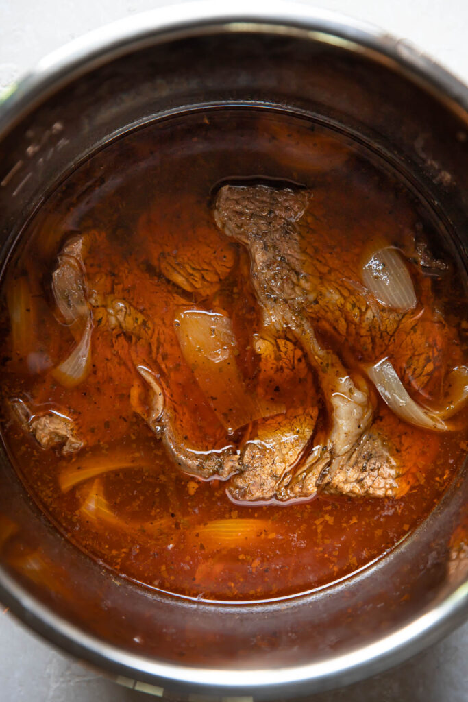 barbacoa in an instant pot with broth.