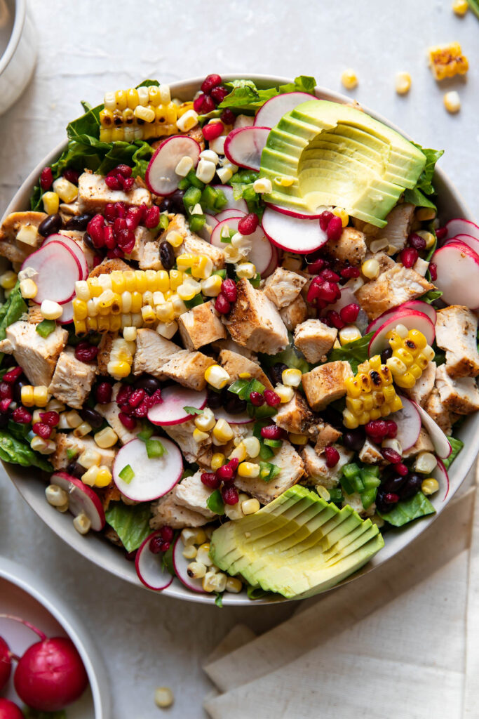 avocado pomegranate chicken salad in a bowl.