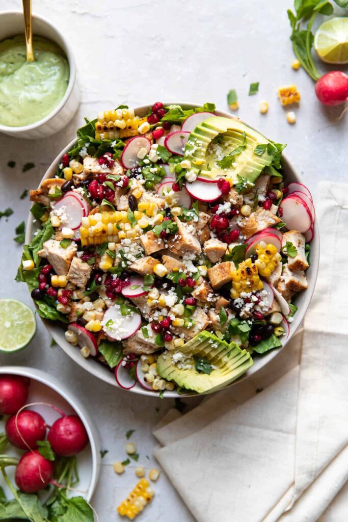 avocado pomegranate chicken salad in a bowl.