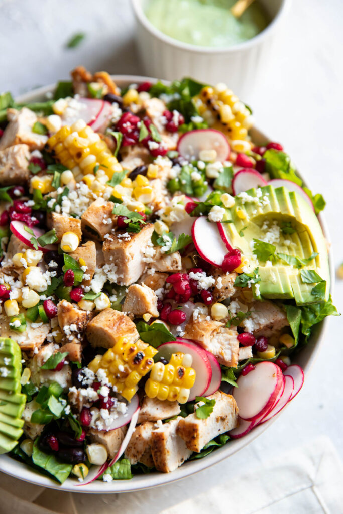 avocado pomegranate chicken salad in a bowl.