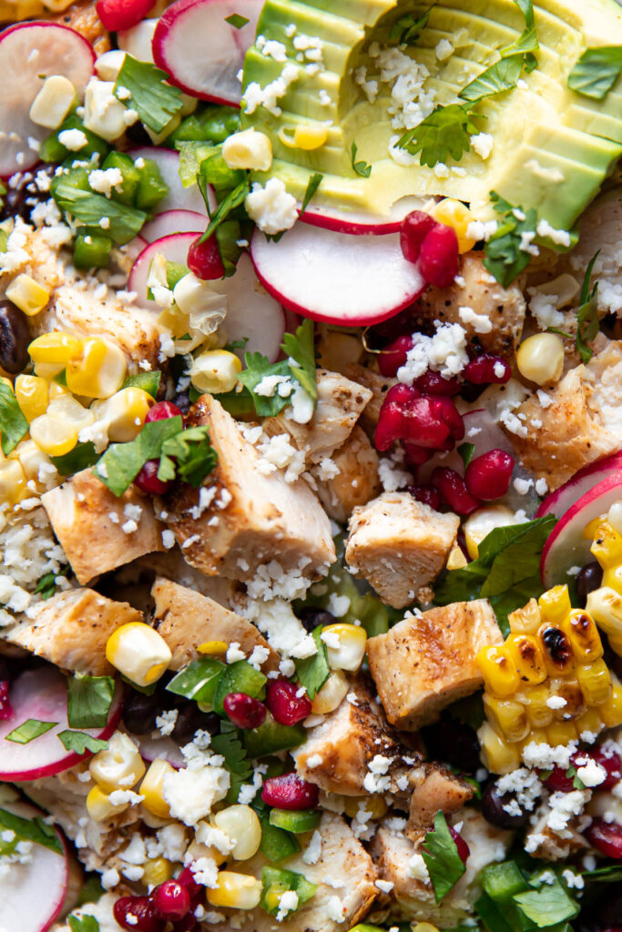 avocado pomegranate chicken salad in a bowl.