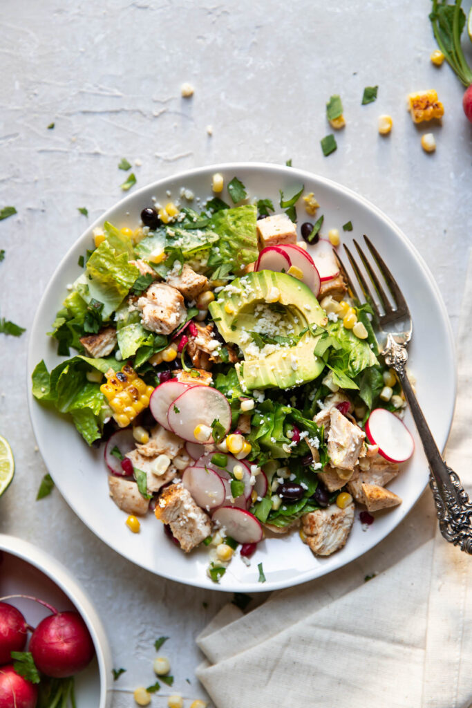 avocado pomegranate chicken salad on a plate.