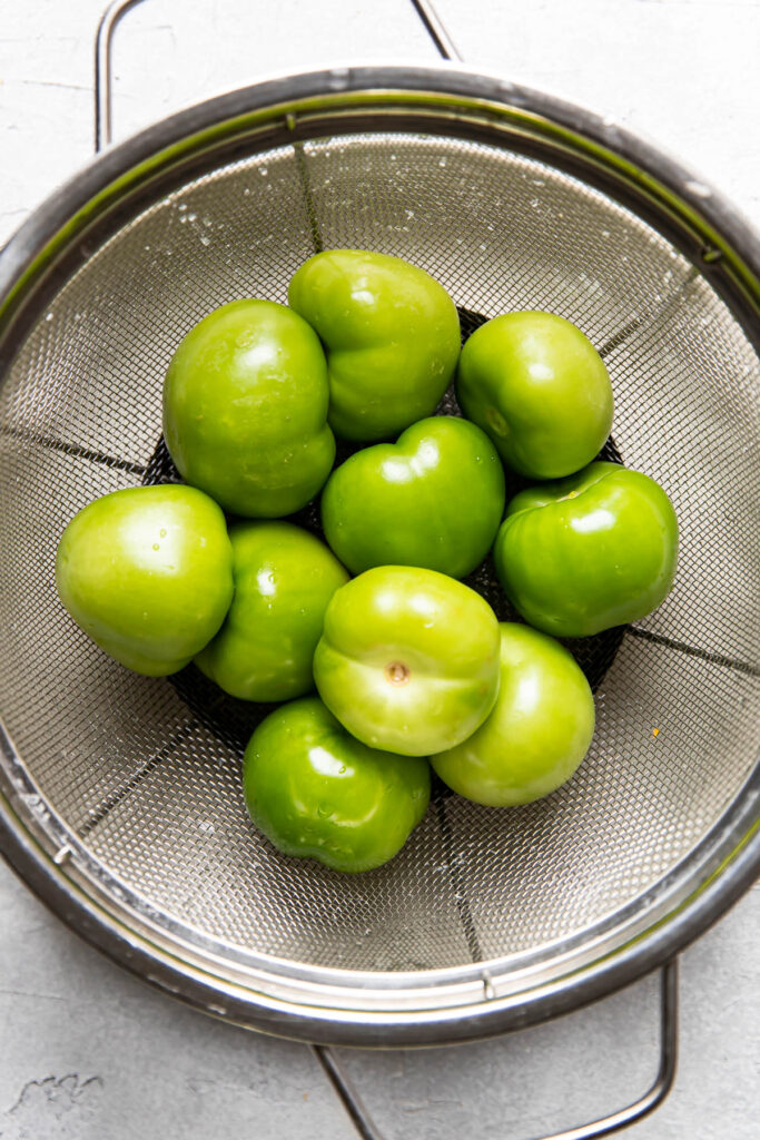 clean tomatillos in a collander.