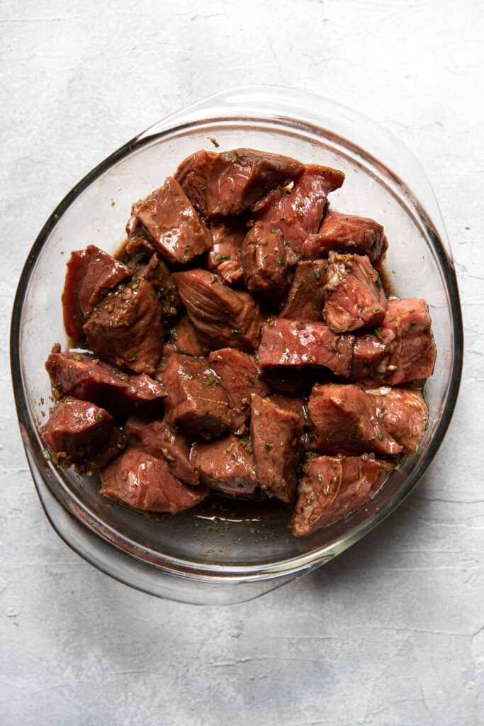 steak marinating in a bowl.