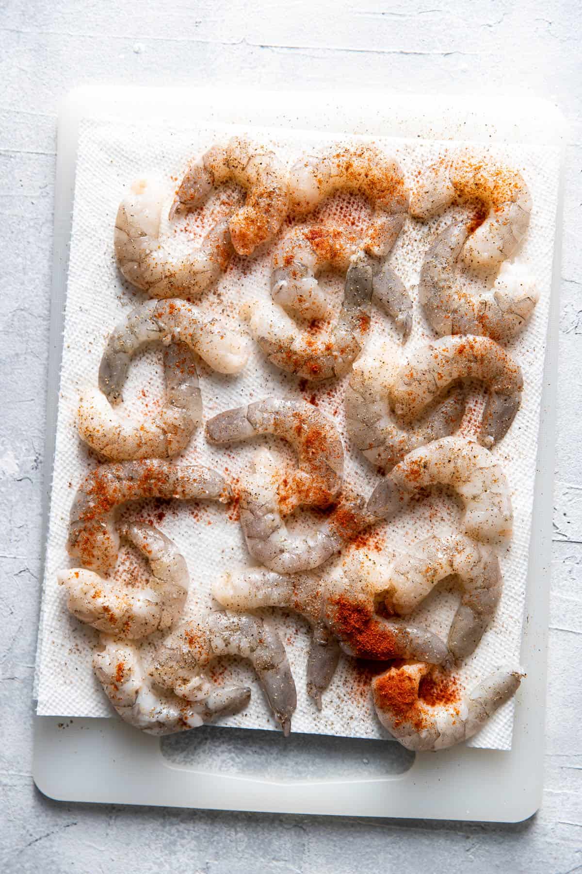 seasoned raw shrimp on a paper towel.