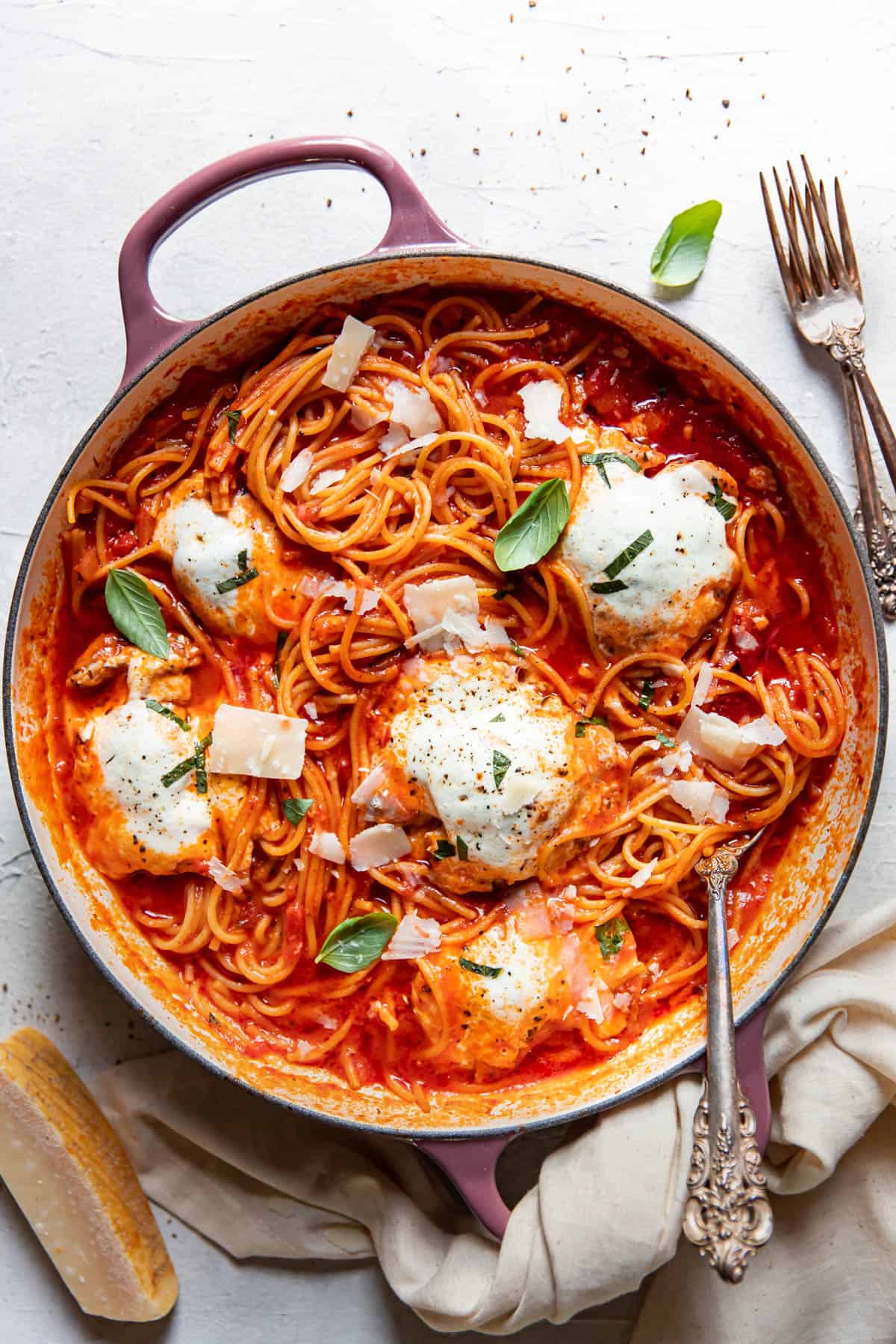 skinny chicken parmesan and spaghetti noodles in a pan.