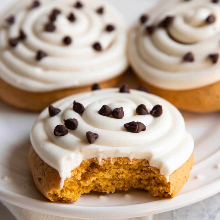 pumpkin cake cookie with cream cheese frosting and chocolate chips on top.
