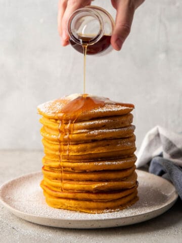 syrup pouring over pumpkin pancakes.
