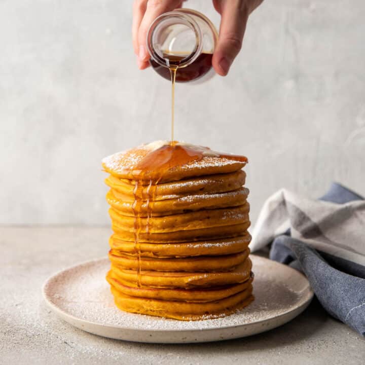 syrup pouring over pumpkin pancakes.