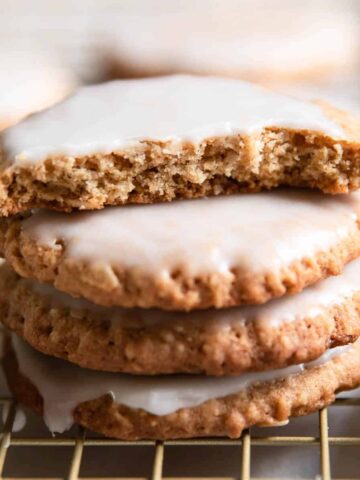 iced oatmeal cookies stacked on each other.