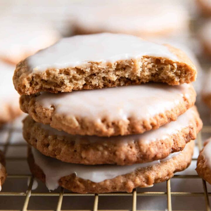 iced oatmeal cookies stacked on each other.