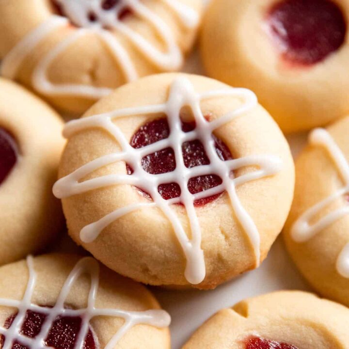 jam thumbprint cookie with icing on a plate.