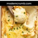 mashed potatoes in in a baking dish with a spoon scooping in it.